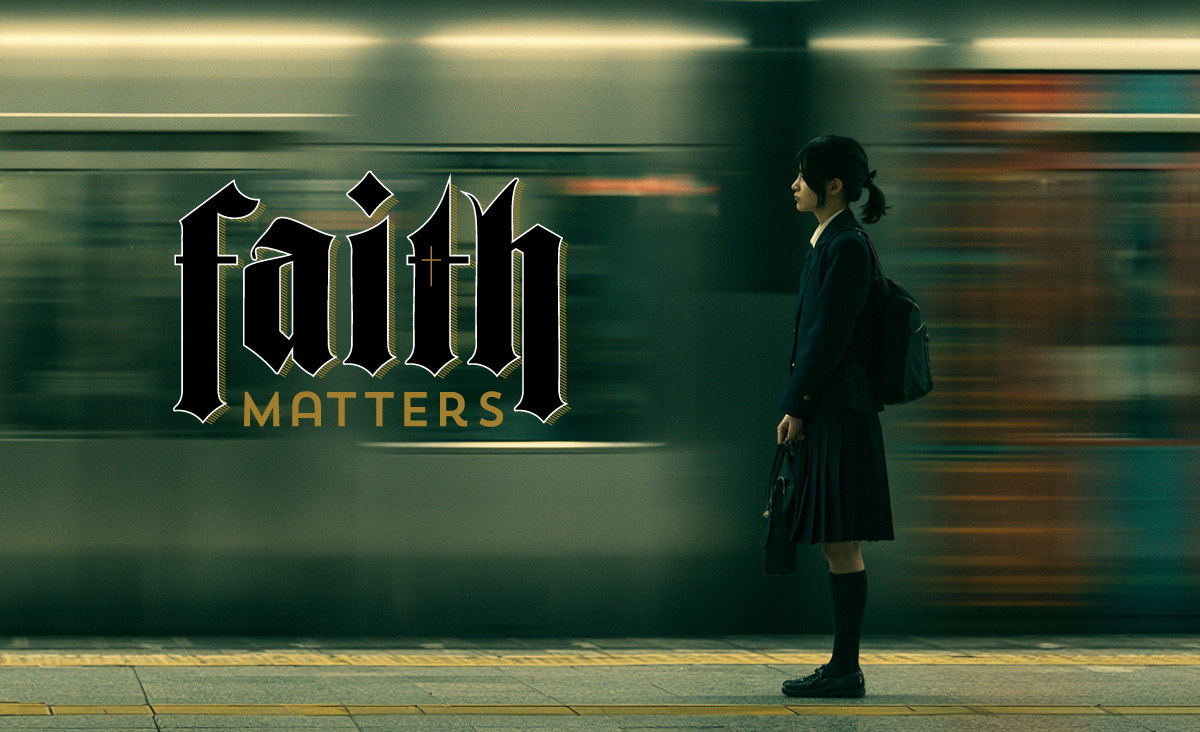 A person stands still beside a blurred passing train, with the Faith Matters logo