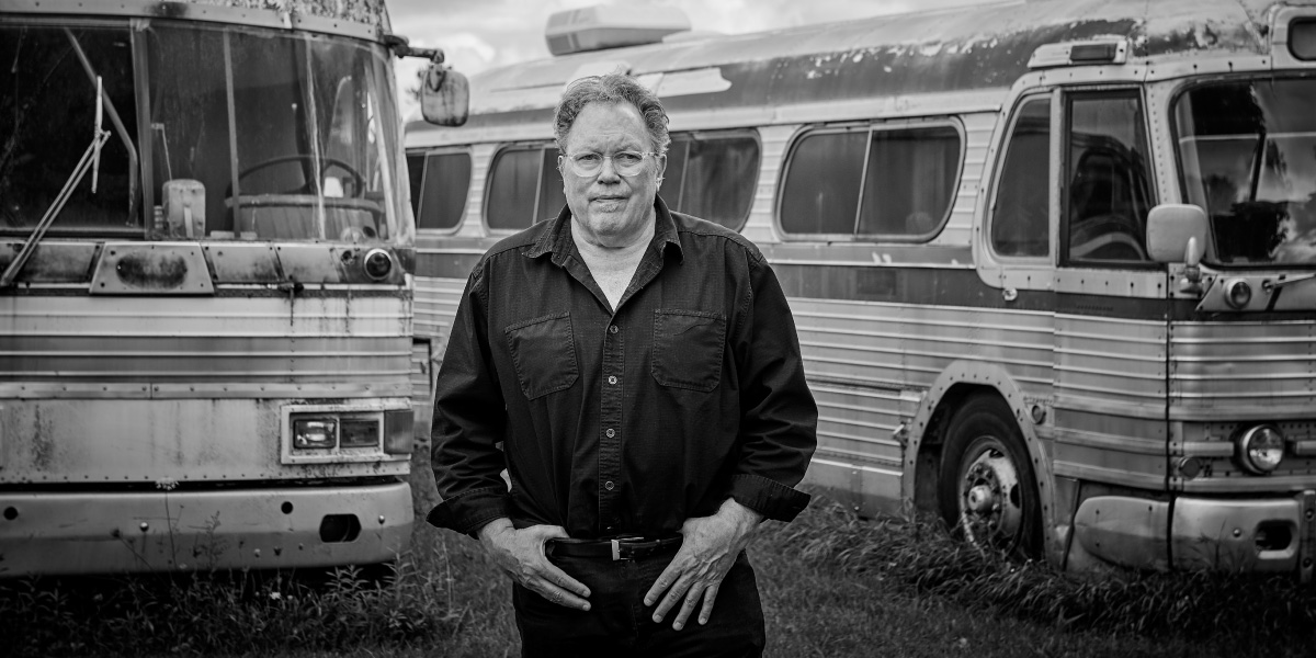 Kevin Matthews standing between vintage buses