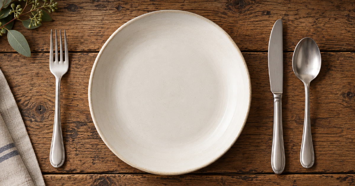 An empty place setting on a rustic wooden table